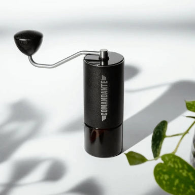 Black coffee grinder with 'Comandante' branding on a light background